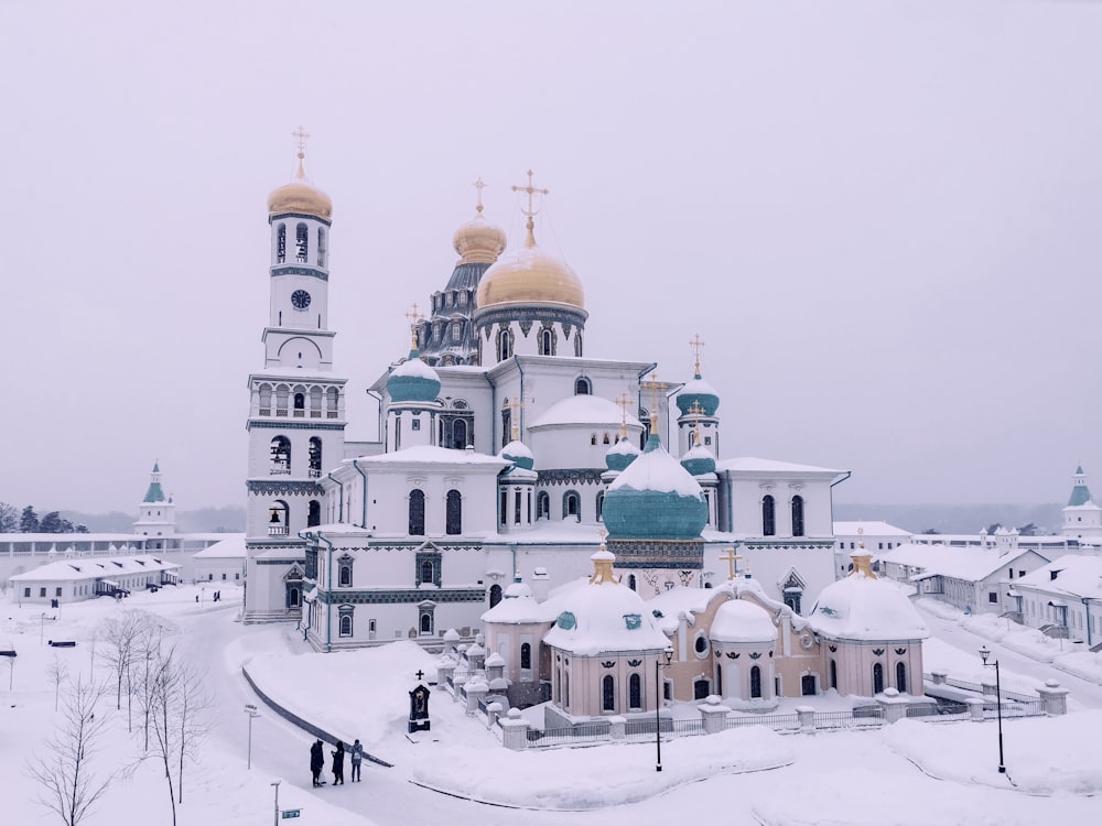 a large white and gold building with a lot of snow on top of it