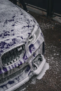 the front of a car covered in snow