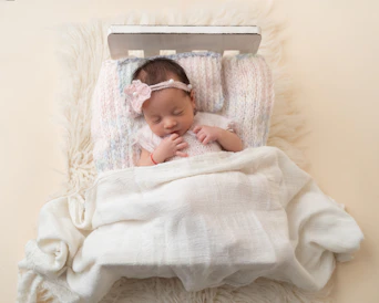 a baby is sleeping in a white blanket