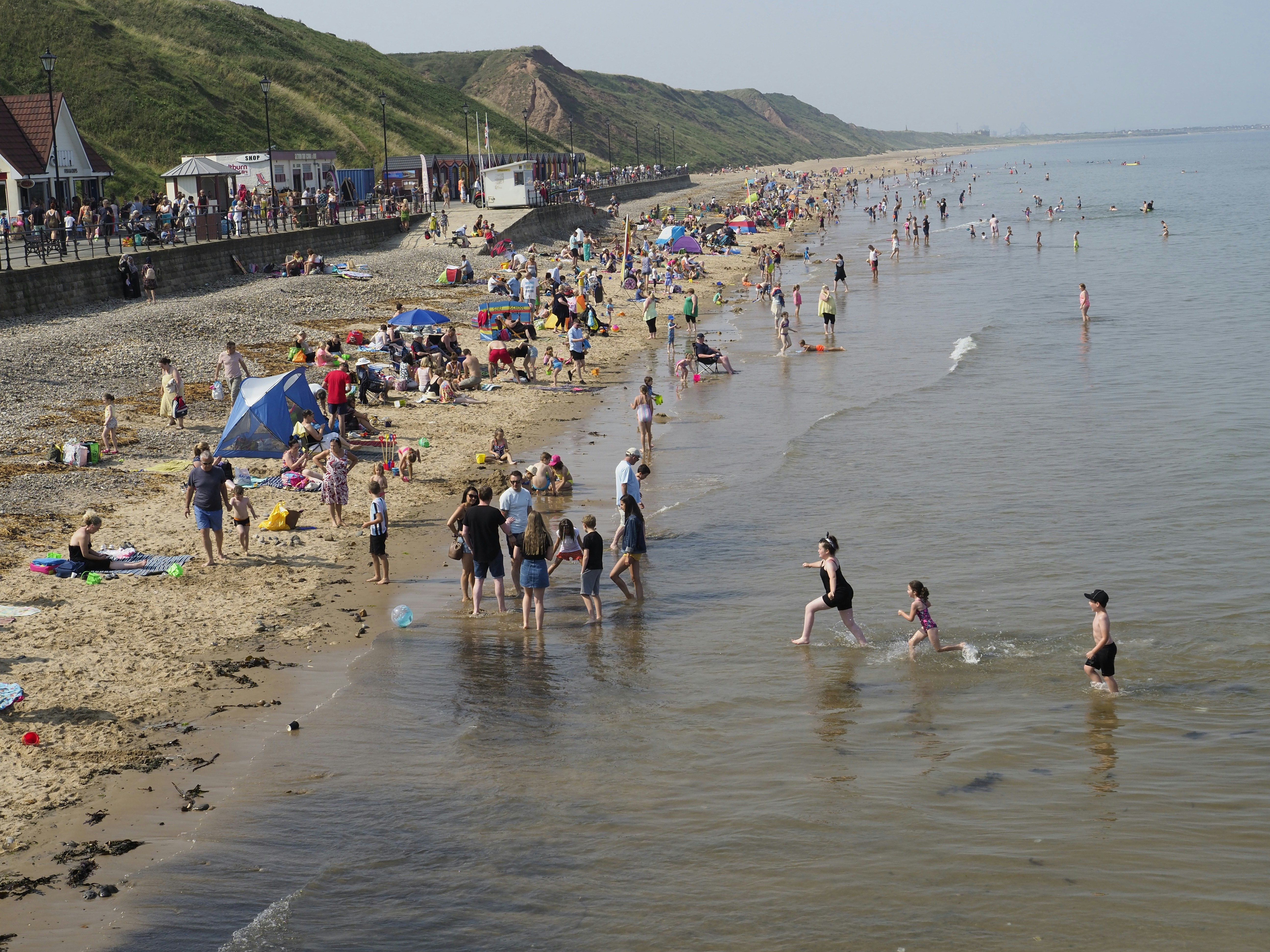 many people are on the beach and in the water