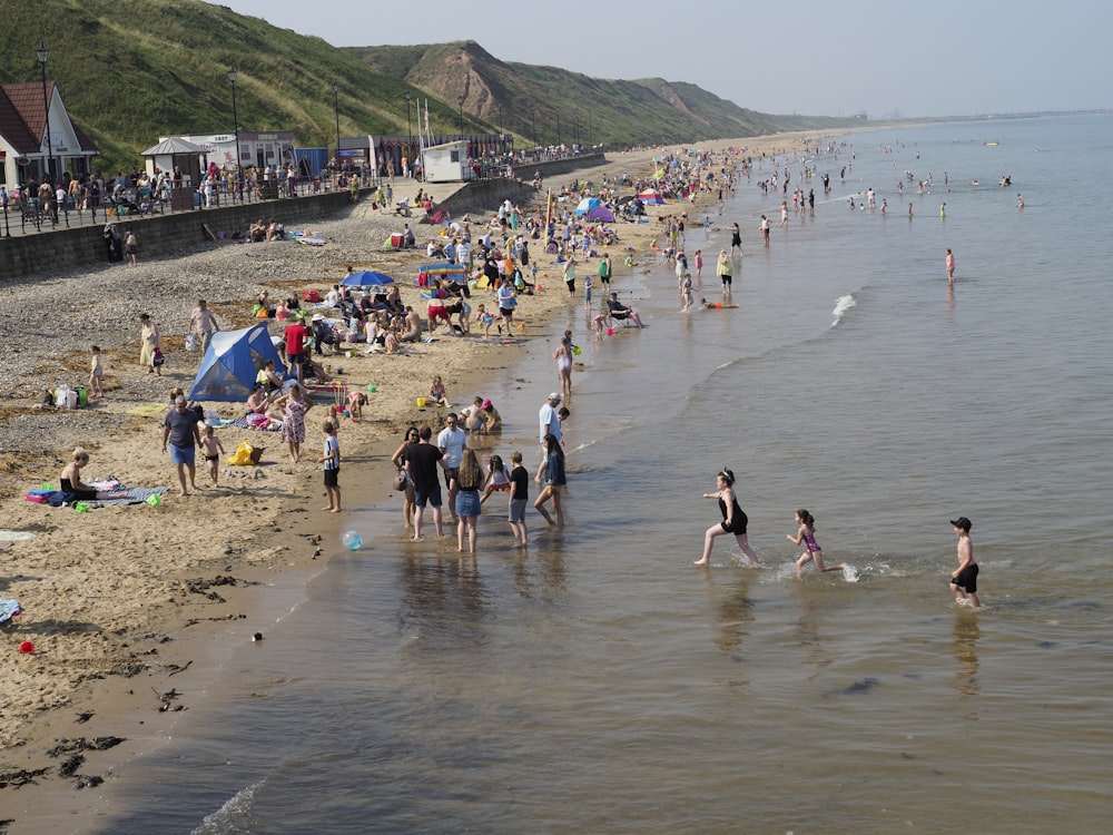 many people are on the beach and in the water