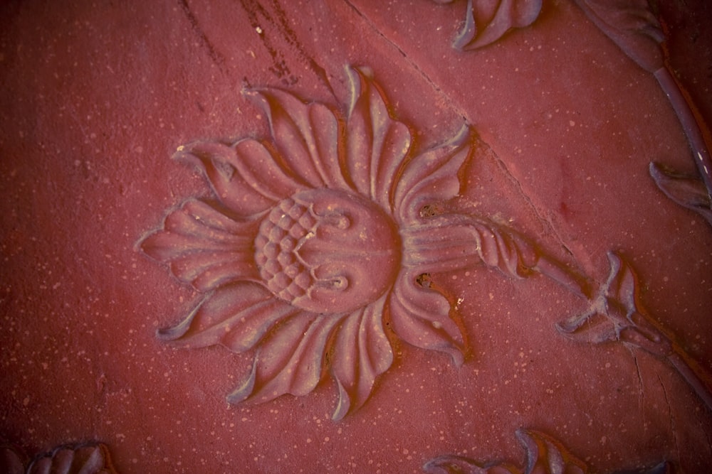 a close up of a flower carving on a wall