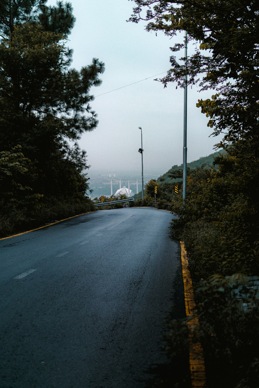 an empty street with a stop light on the side of it