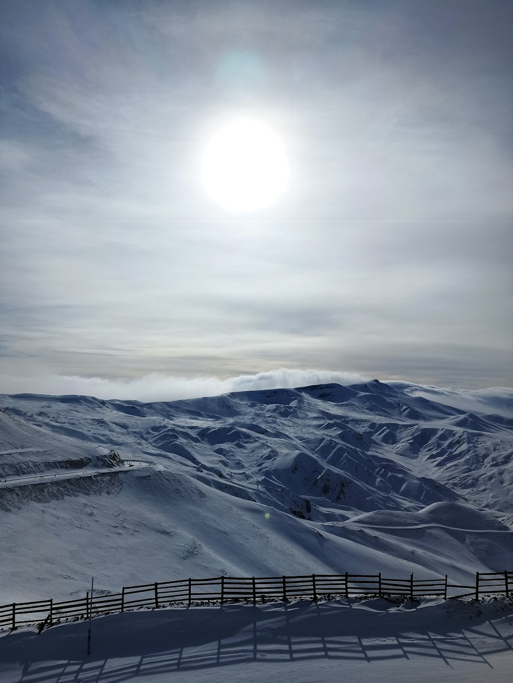 the sun is shining over a snowy mountain