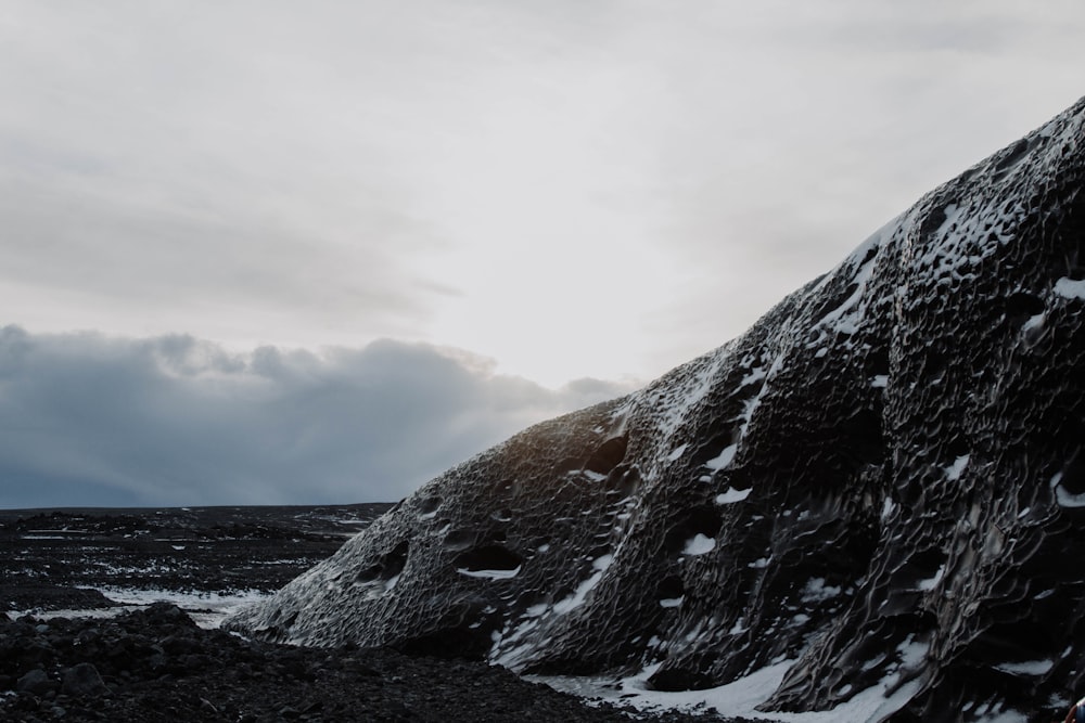 a rocky mountain with snow on the ground