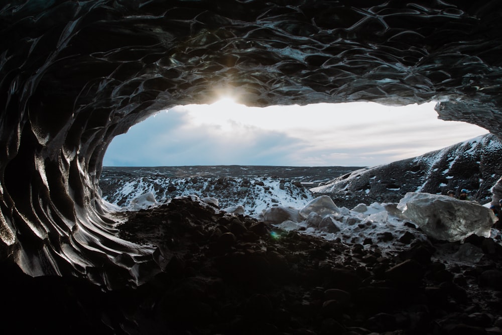 the sun is shining through an ice cave
