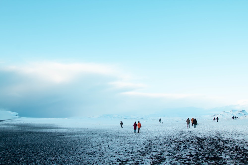 a group of people walking across a snow covered field