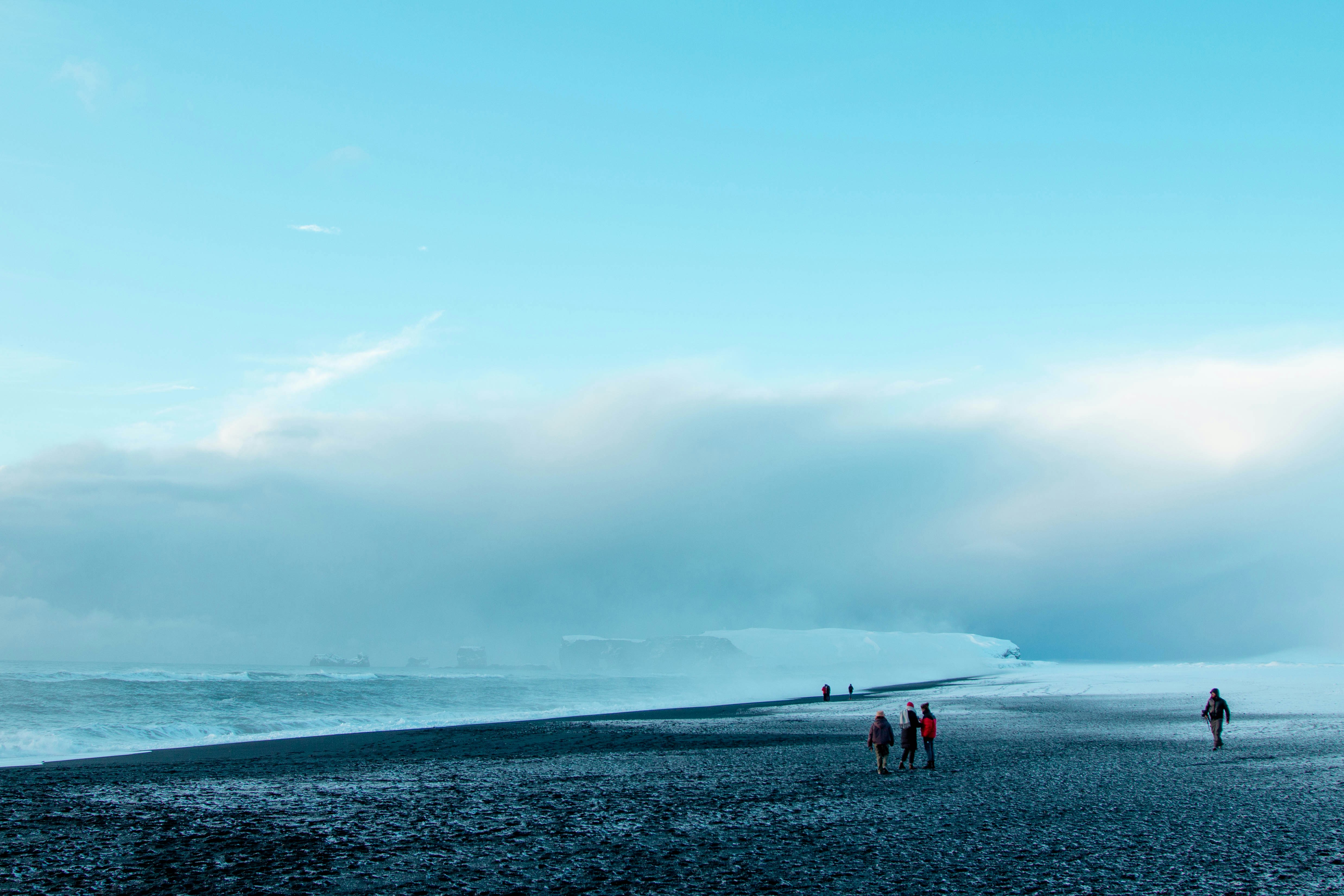 un groupe de personnes debout au sommet d’une plage