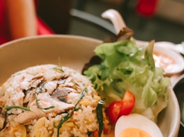 a bowl of rice, eggs, and vegetables on a table