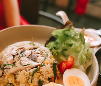 a bowl of rice, eggs, and vegetables on a table