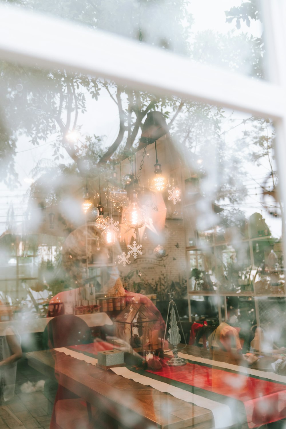 a person sitting at a table in front of a window