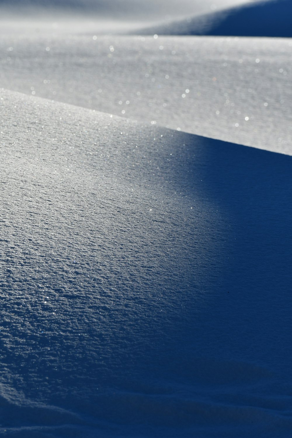 a snow covered hill with a snowboarder in the distance