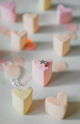 Artisan handmade marshmallows arranged elegantly on a rustic wooden board with subtle pastel accents.