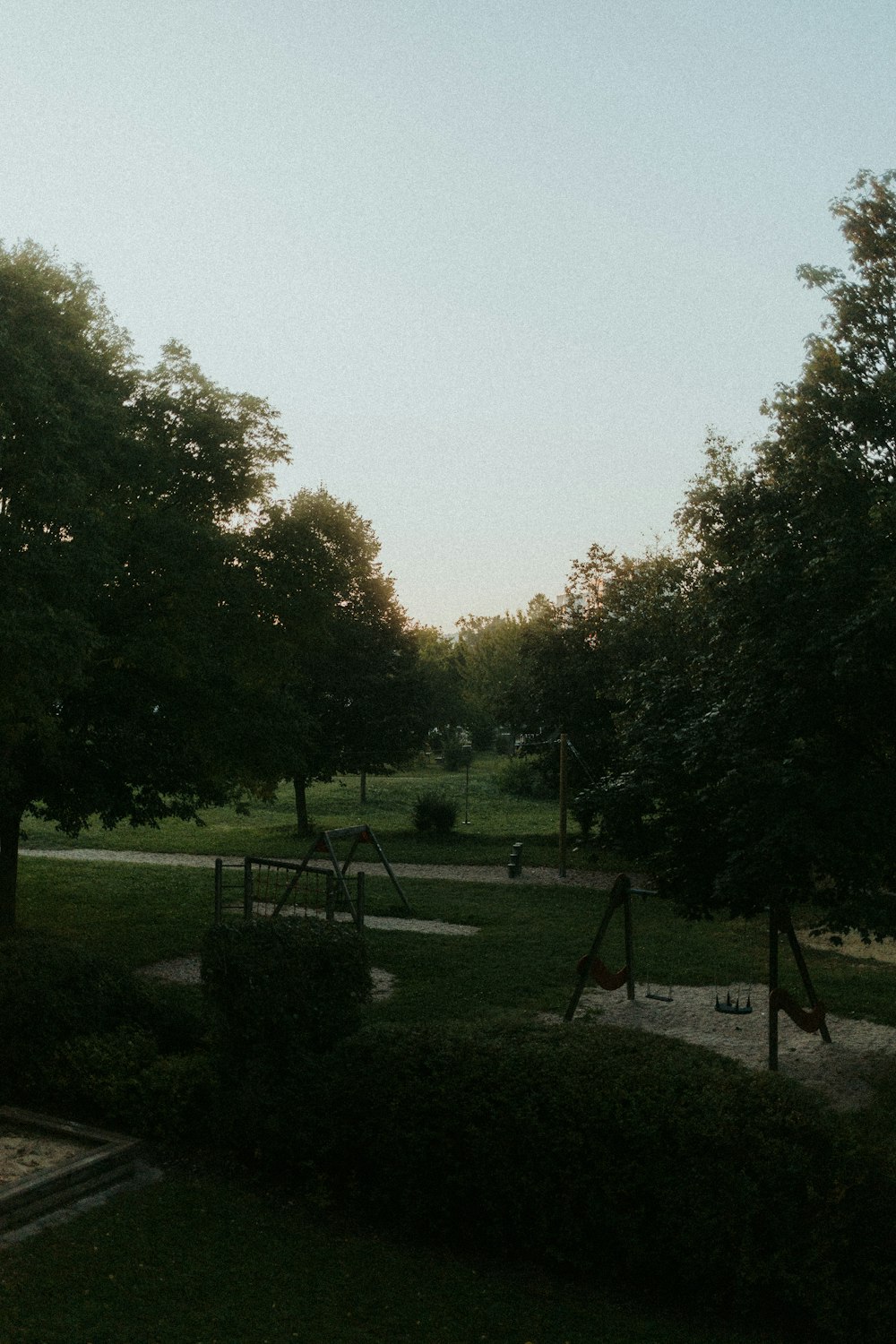 a park with a swing set and trees