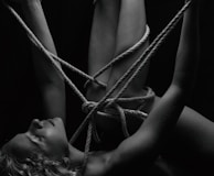 An intimate scene with silk ropes artfully tied, hinting at trust and adventure.
