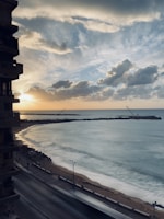 A travel influencer capturing a scenic sunset on a coastal boardwalk.