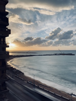 A travel influencer capturing a scenic sunset on a coastal boardwalk.