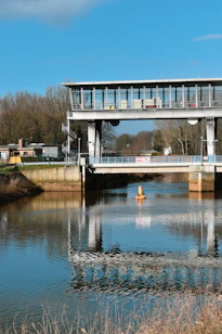 a bridge over a body of water with a building in the background