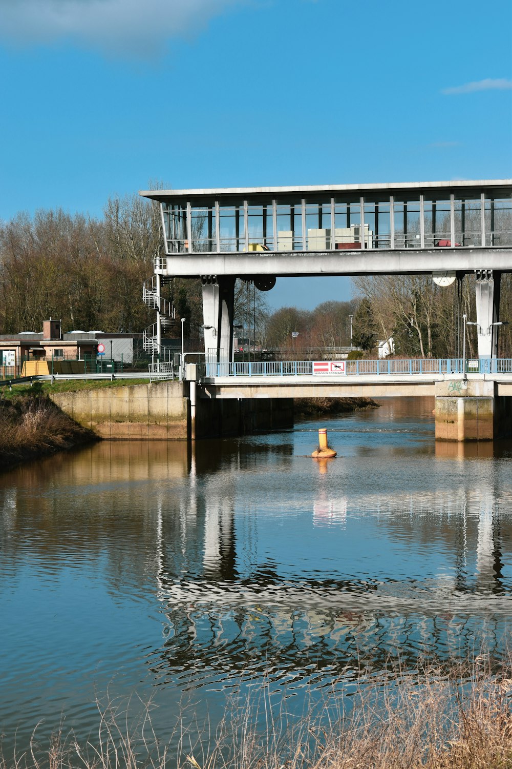 a bridge over a body of water with a building in the background