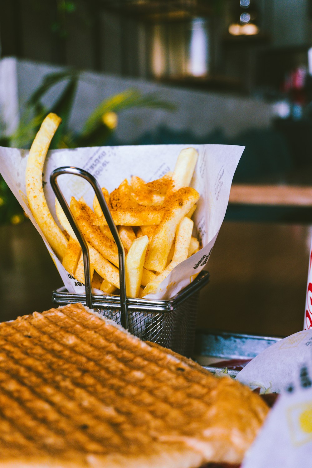 a basket filled with french fries next to a sandwich