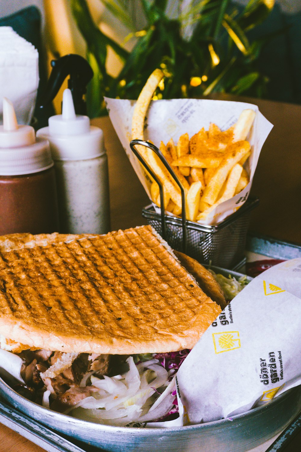 a waffle sandwich and french fries on a tray