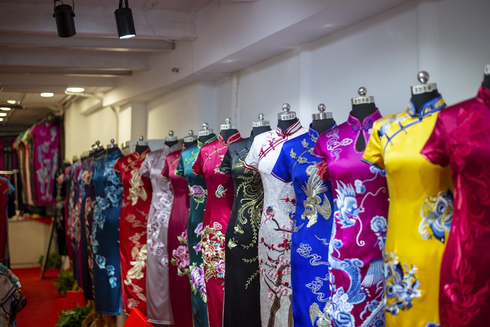 a row of colorful dresses on display in a store