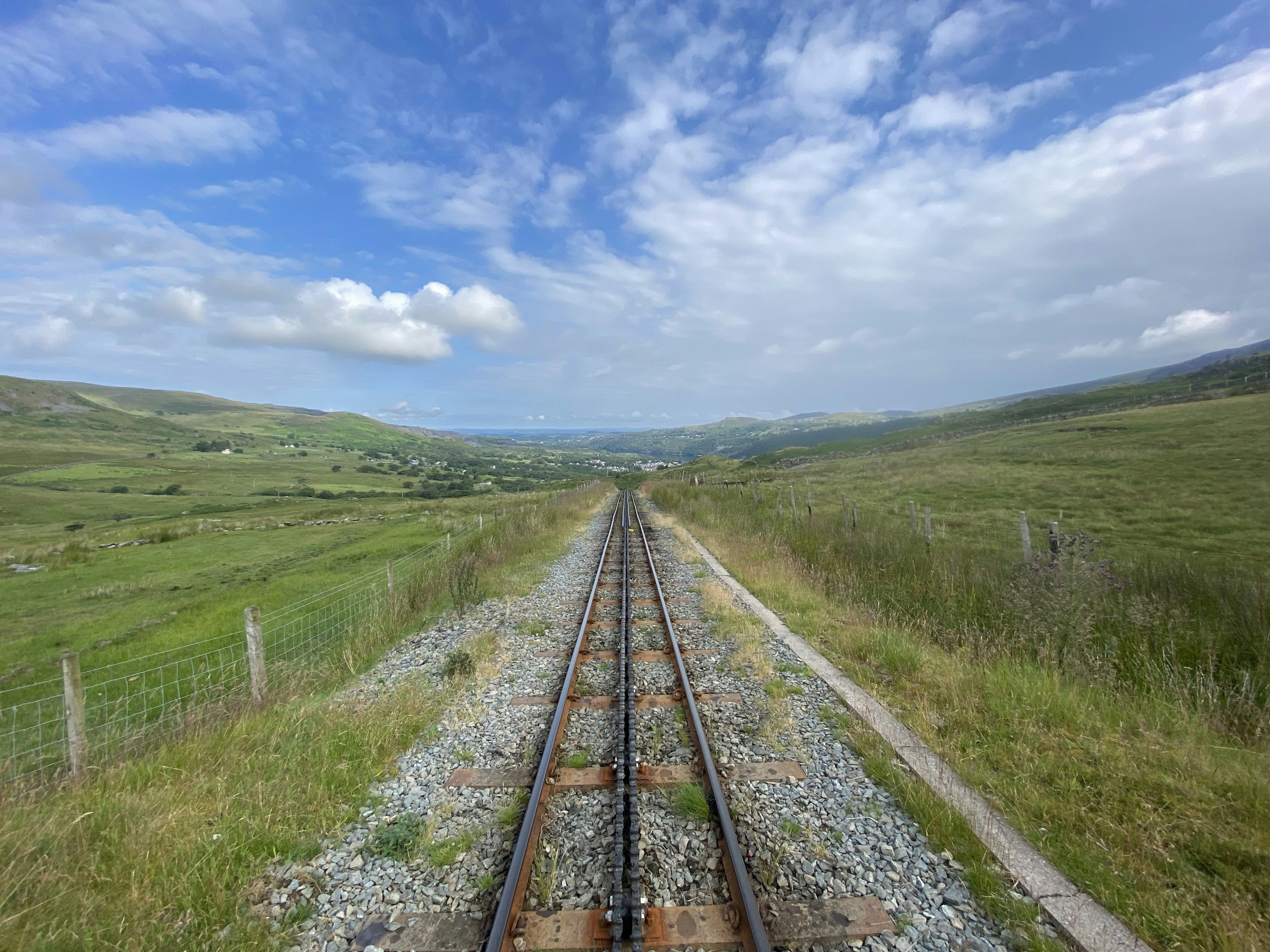 a train track running through a lush green countryside