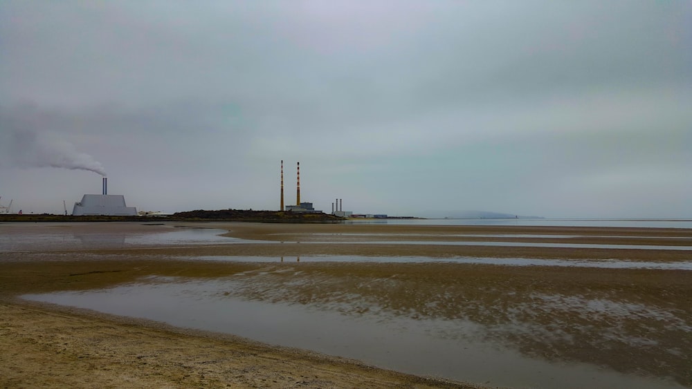 a factory with smoke coming out of it near a body of water