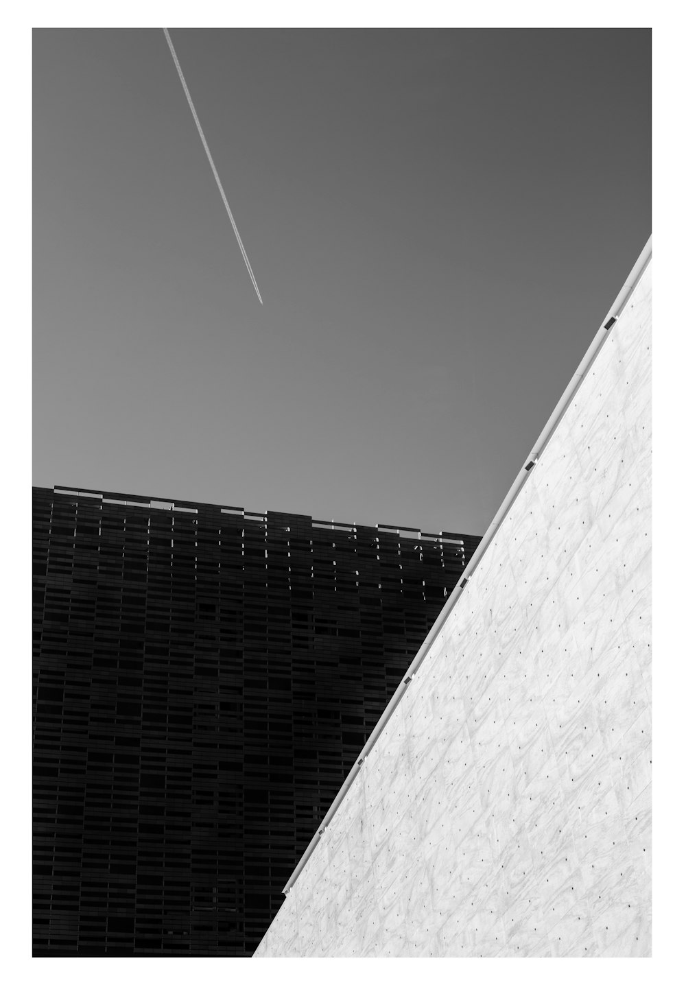 a black and white photo of an airplane in the sky