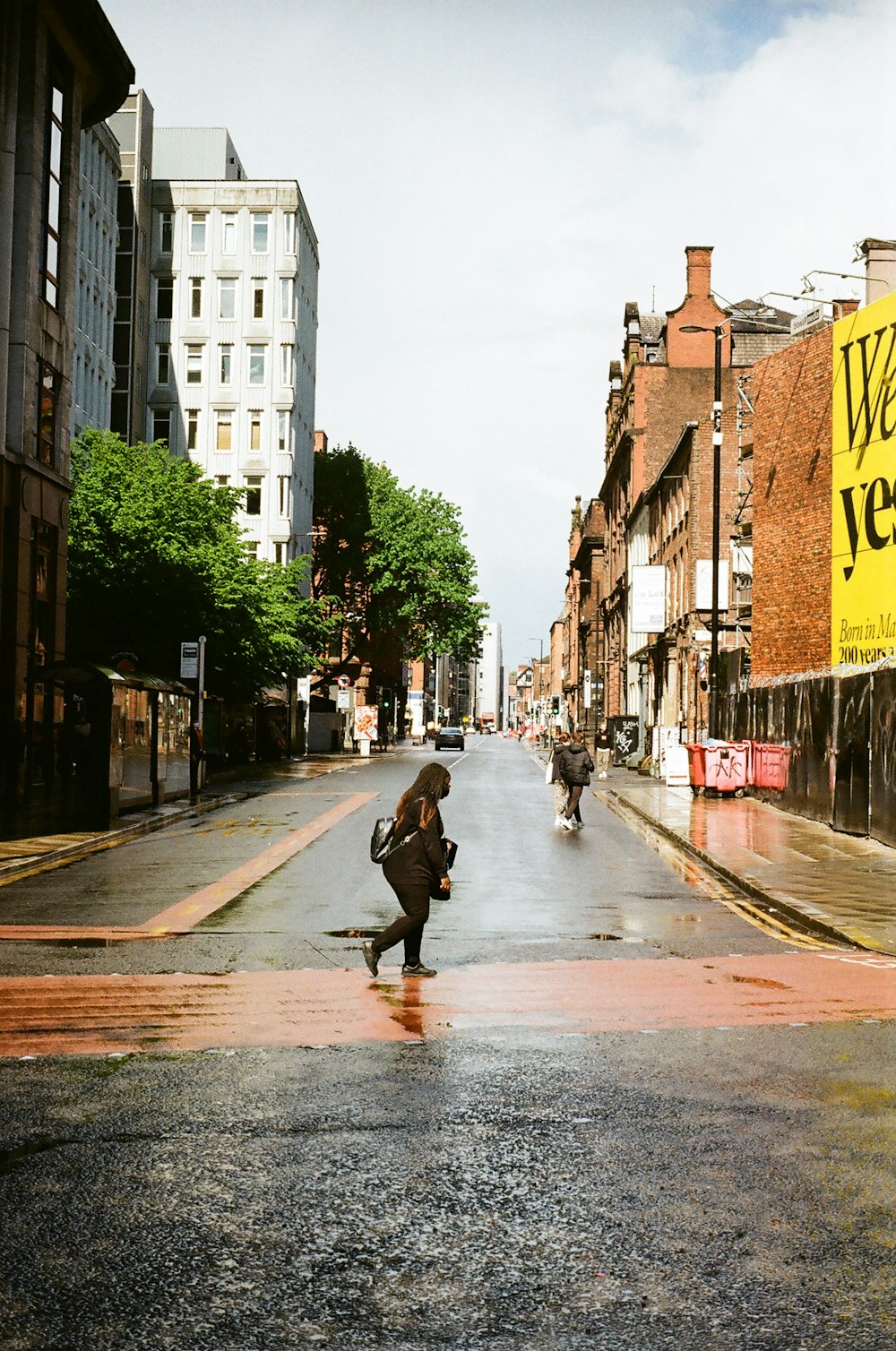 a person is walking down a wet street