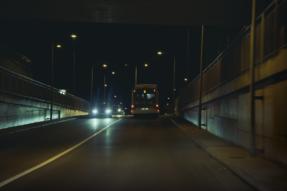 a bus driving down a street at night