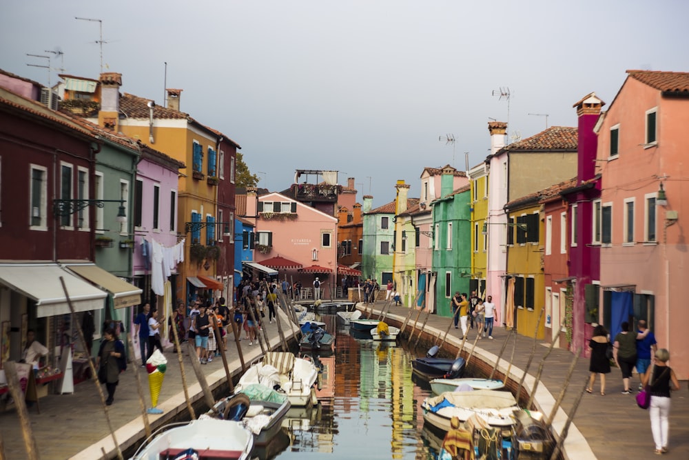 a canal filled with lots of boats next to tall buildings