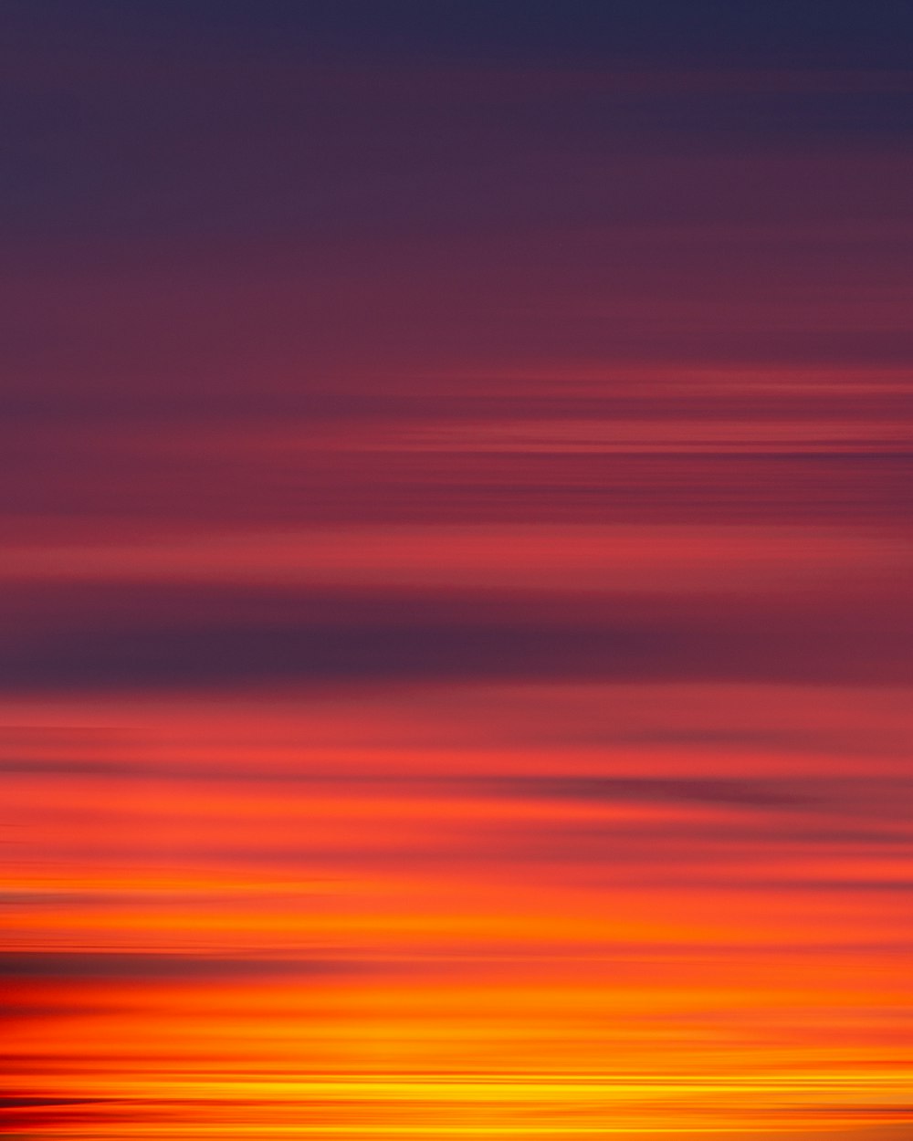 a plane flying in the sky at sunset