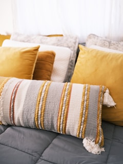 a bed topped with lots of pillows and blankets
