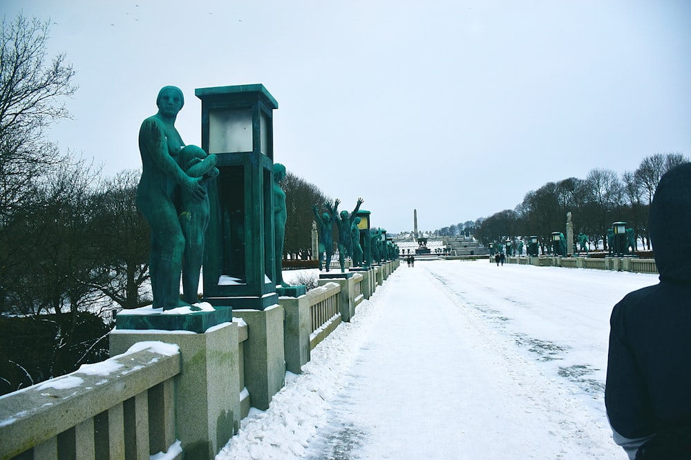 a person standing next to a statue in the snow