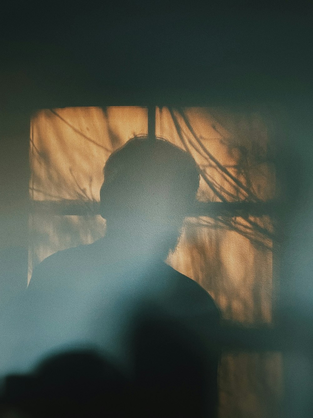 a silhouette of a person in front of a window