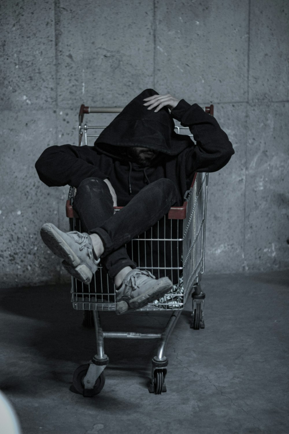 a man is sitting in a shopping cart