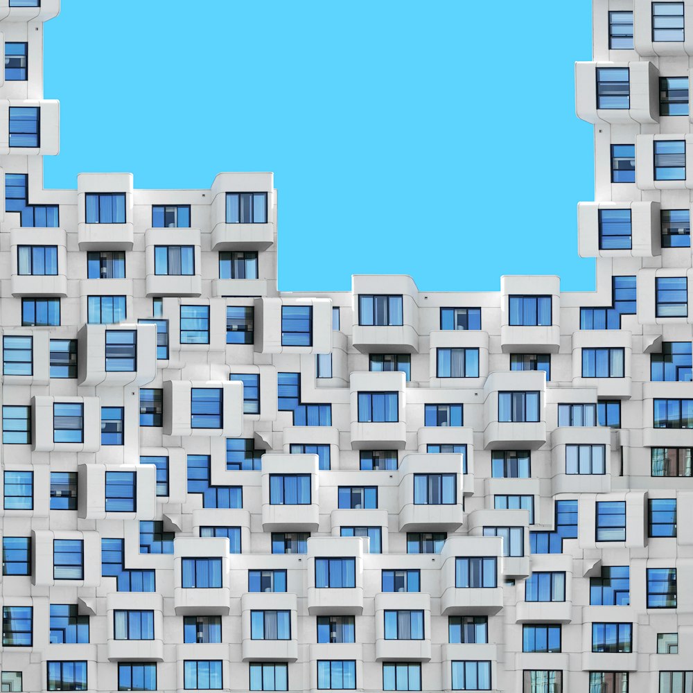 a tall building with many windows and a blue sky in the background