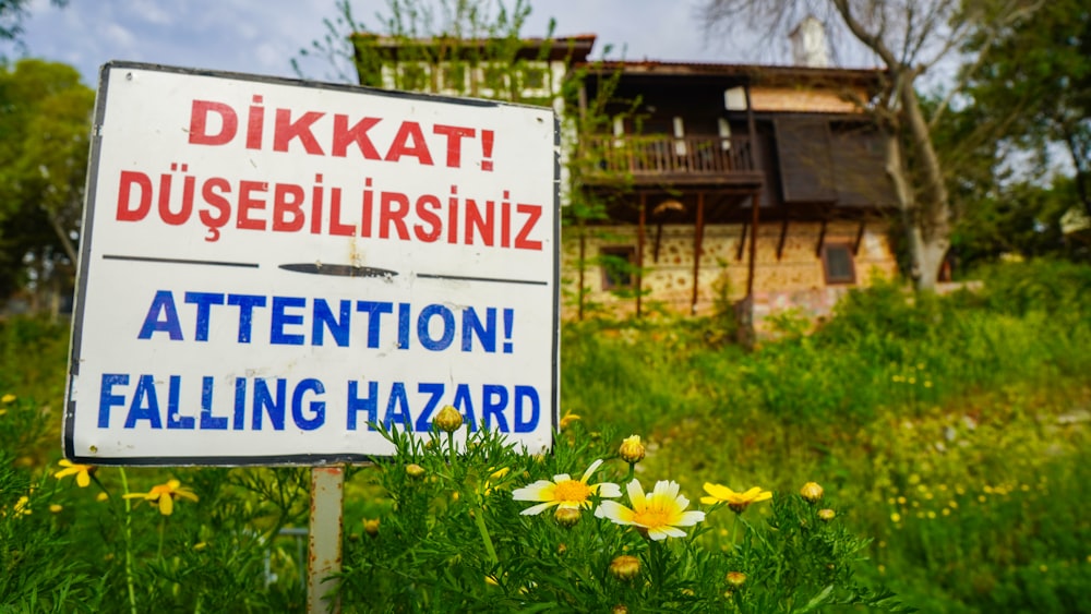 a sign that is in the grass near flowers