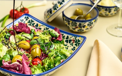 a bowl of salad with olives and tomatoes