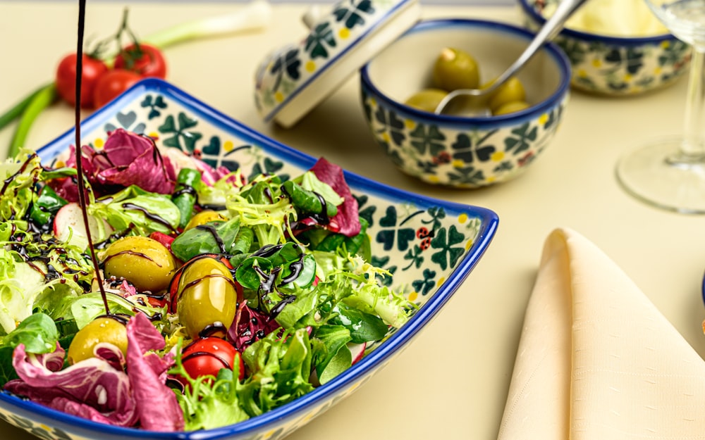 a bowl of salad with olives and tomatoes