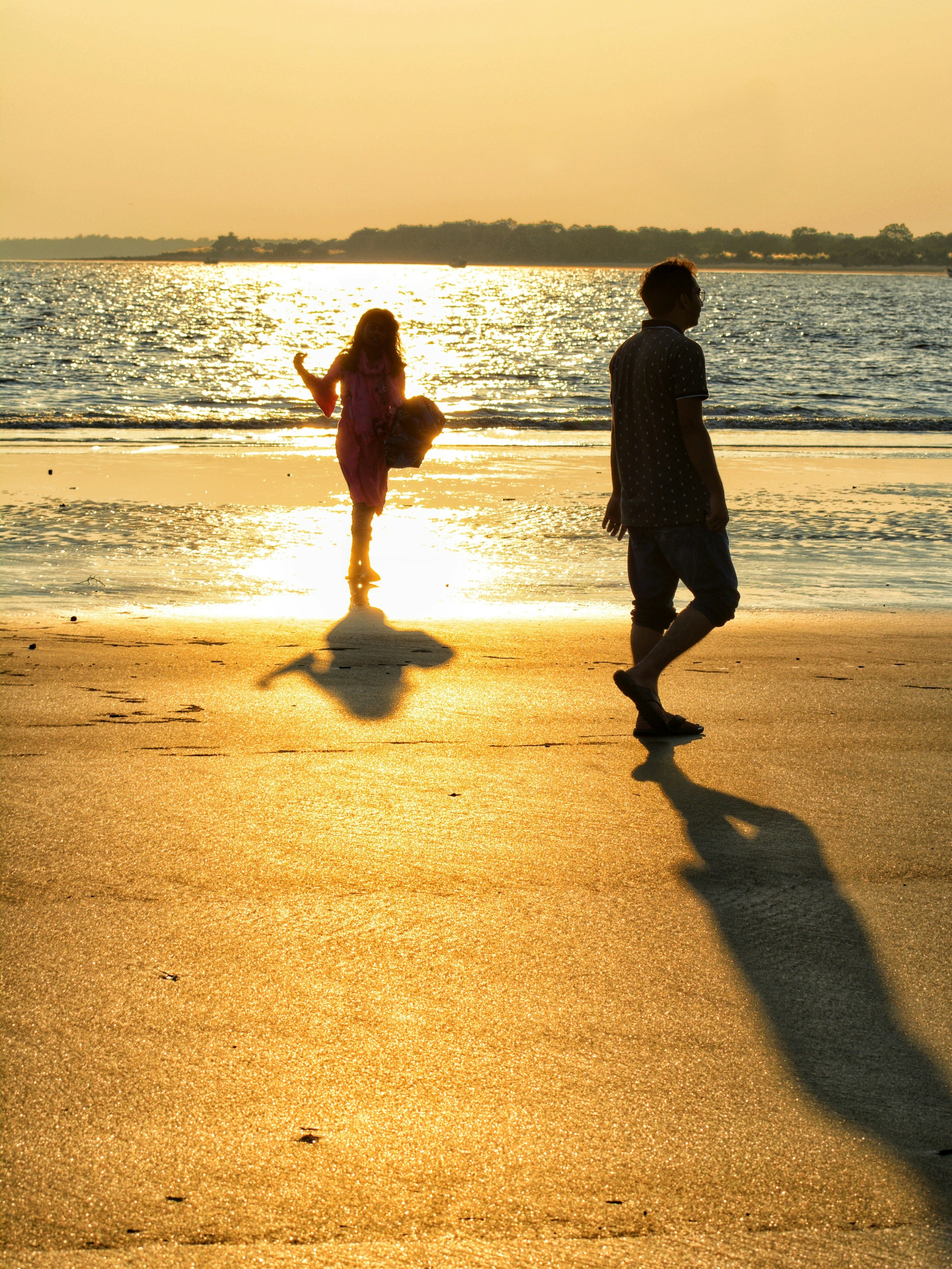a couple of people standing on top of a beach