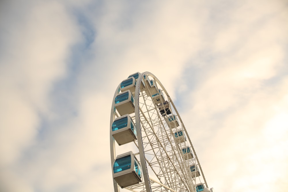 a ferris wheel with blue windows against a cloudy sky