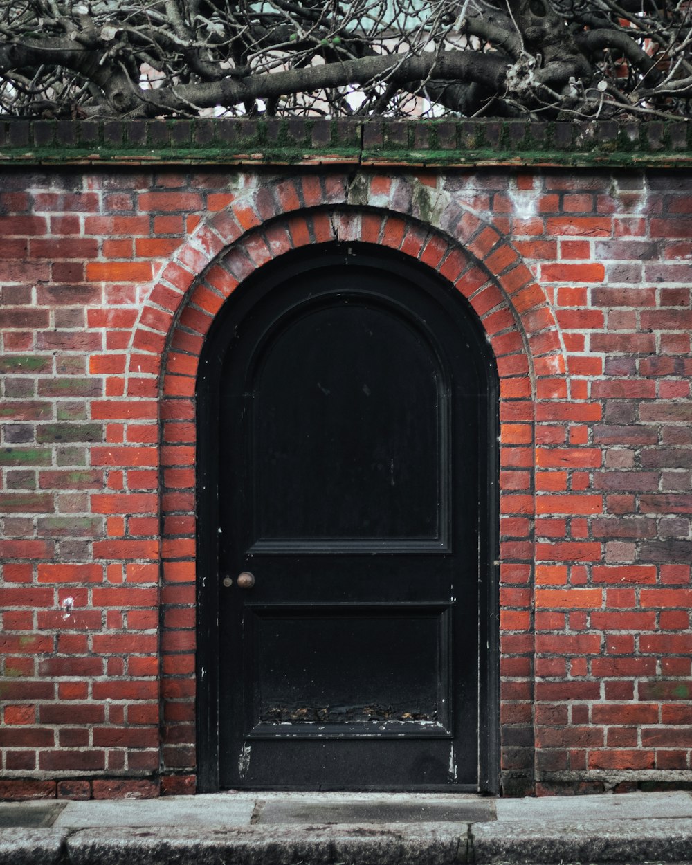 a black door on a red brick wall