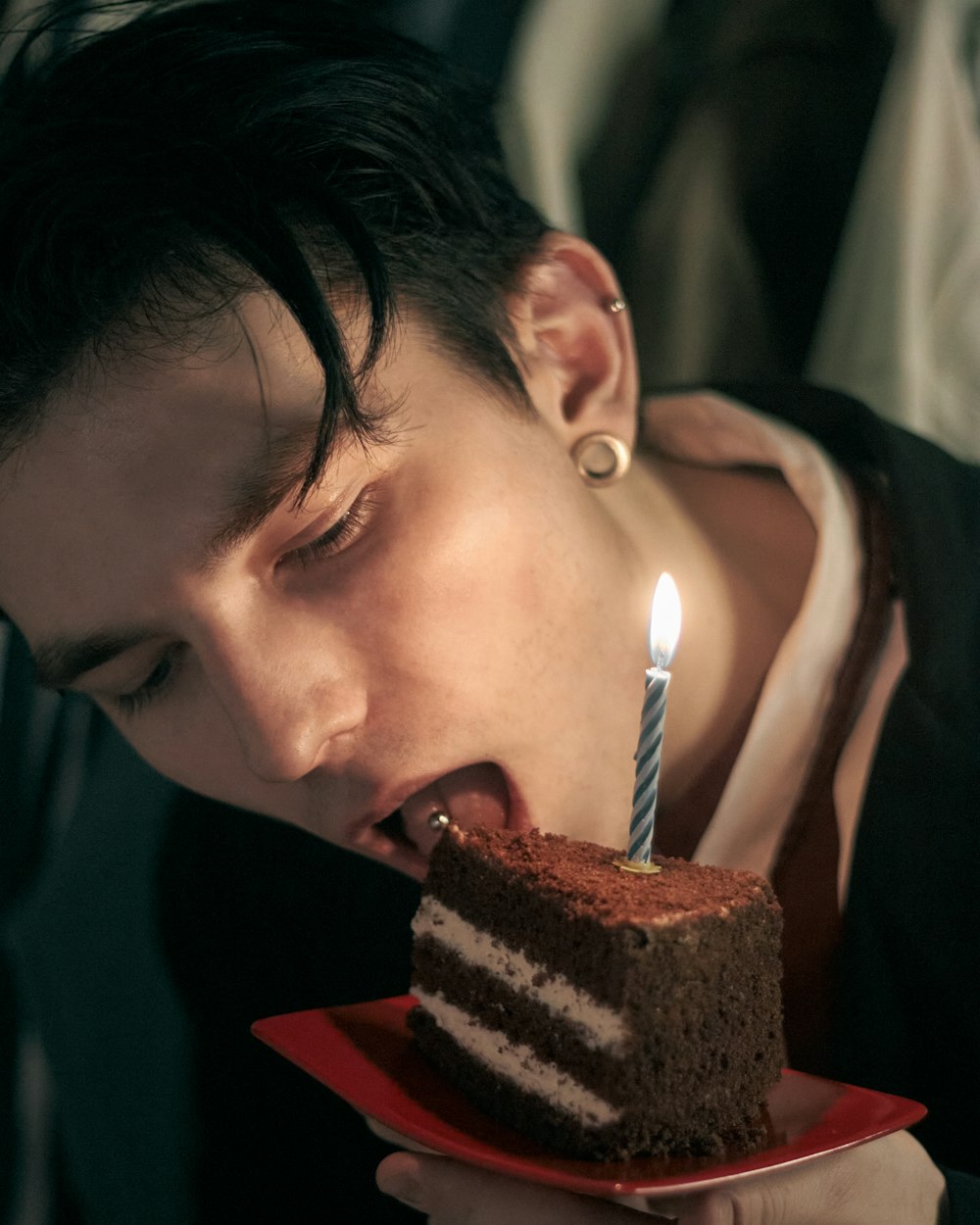a man blowing out a candle on a piece of cake