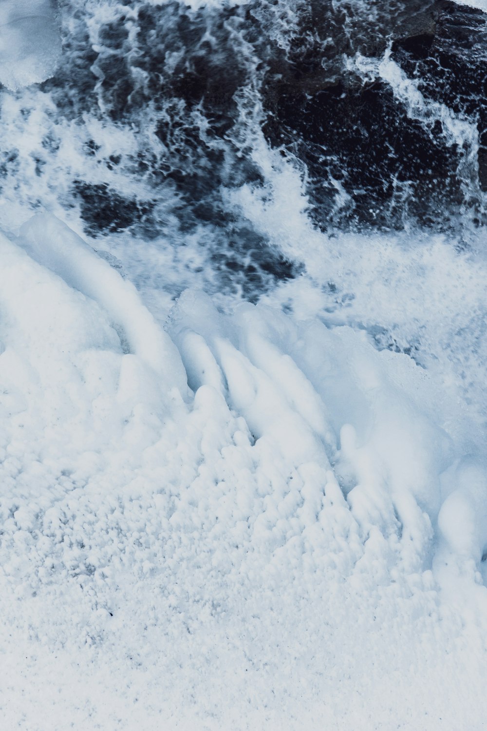 a man riding a snowboard down a snow covered slope