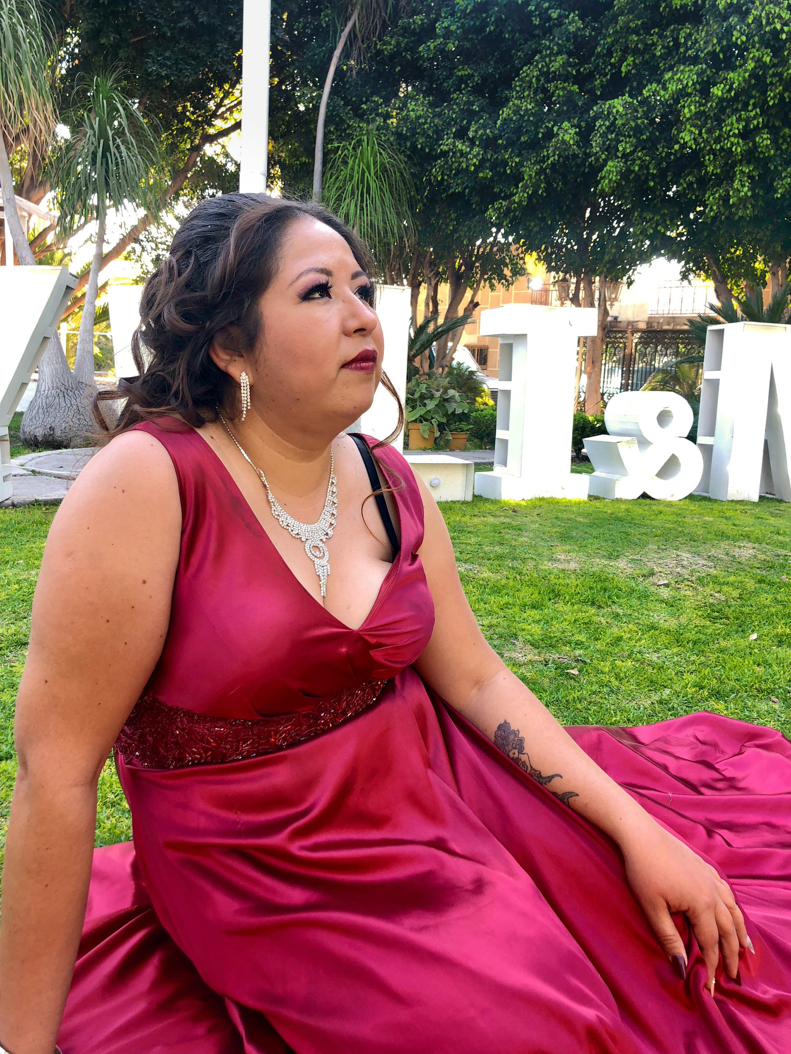 A woman in a red dress sitting on the grass photo – Free Apparel Image ...