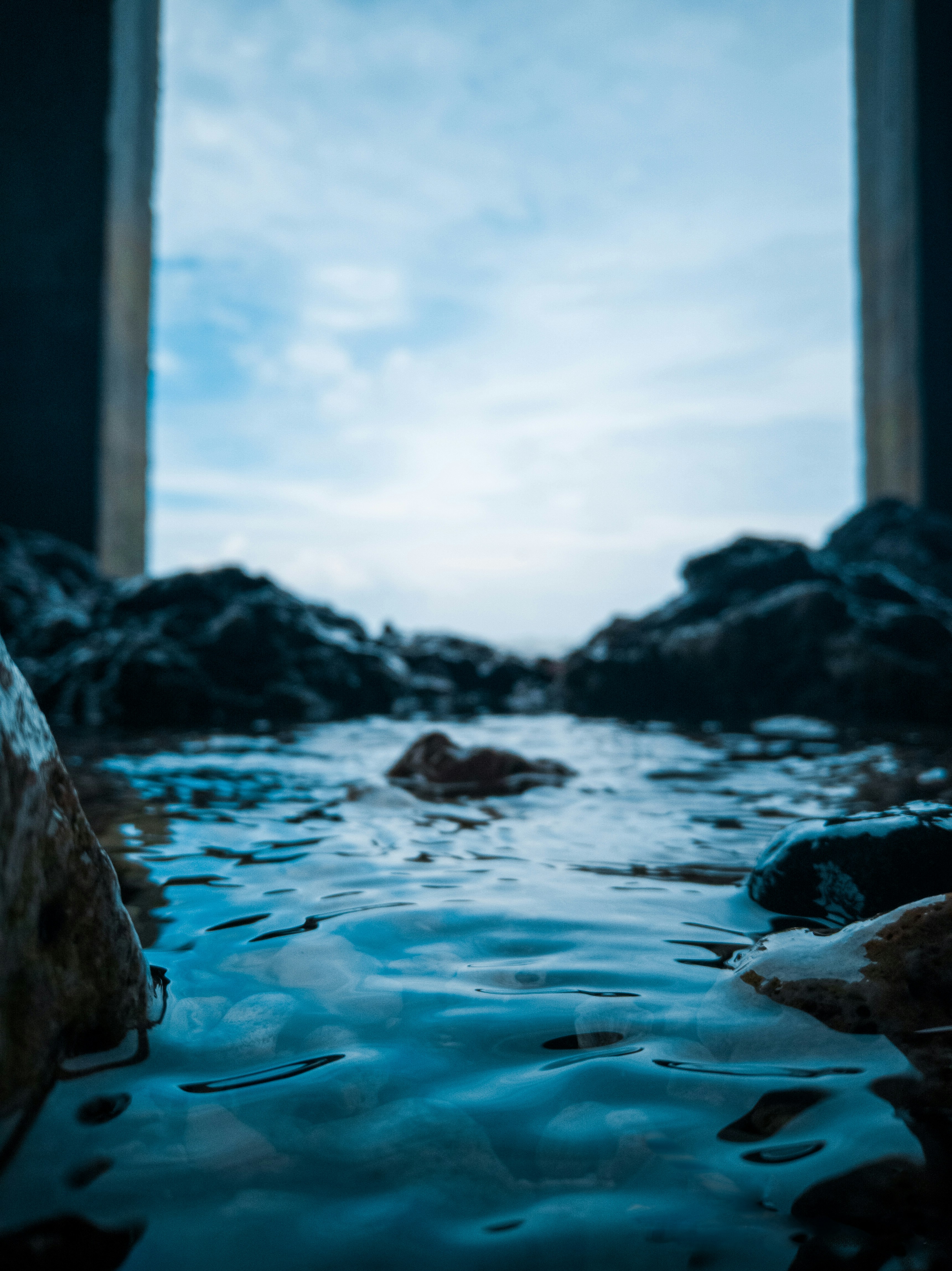 a view of a body of water with rocks in the background