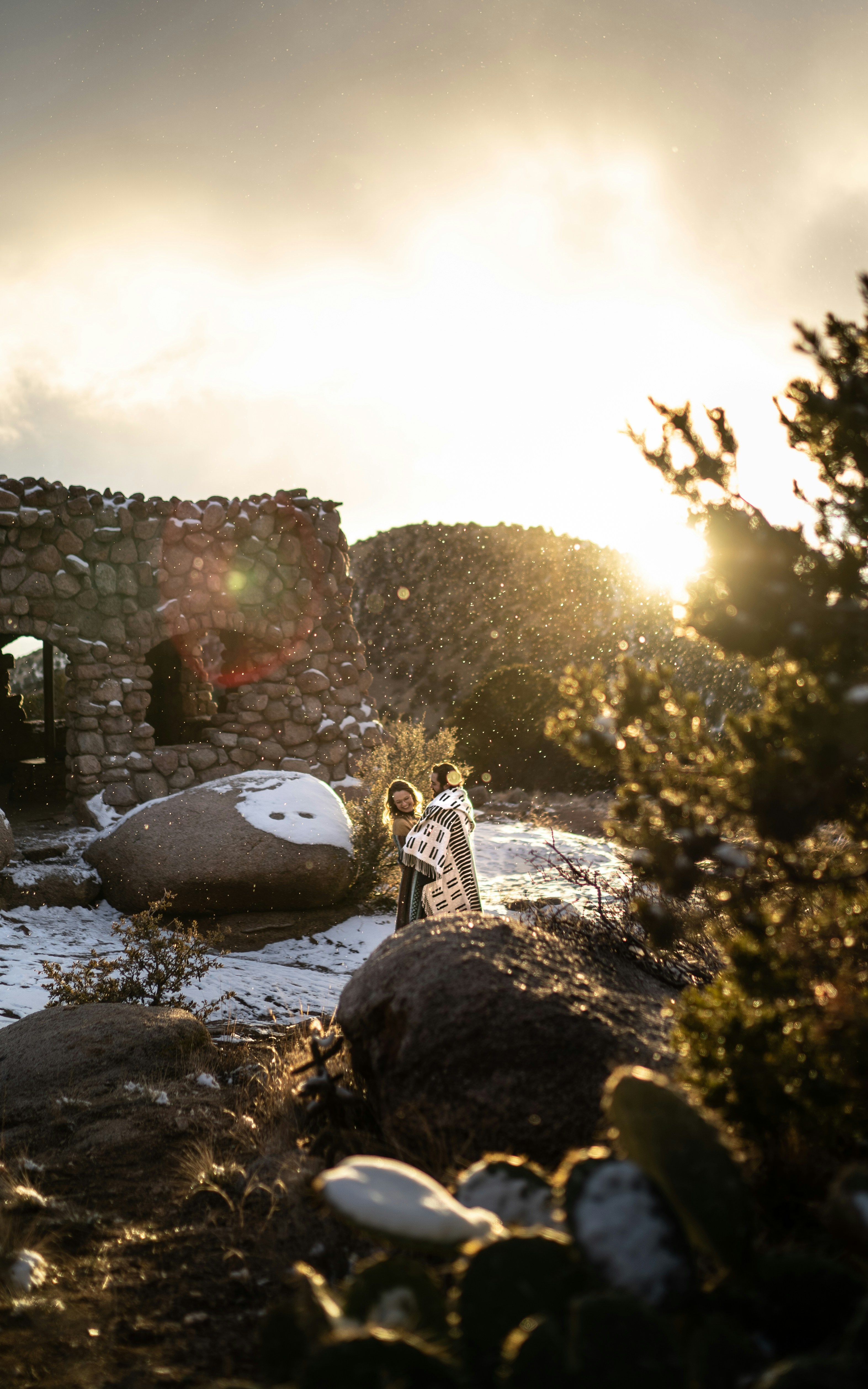 a woman standing on a rocky hillside next to a building