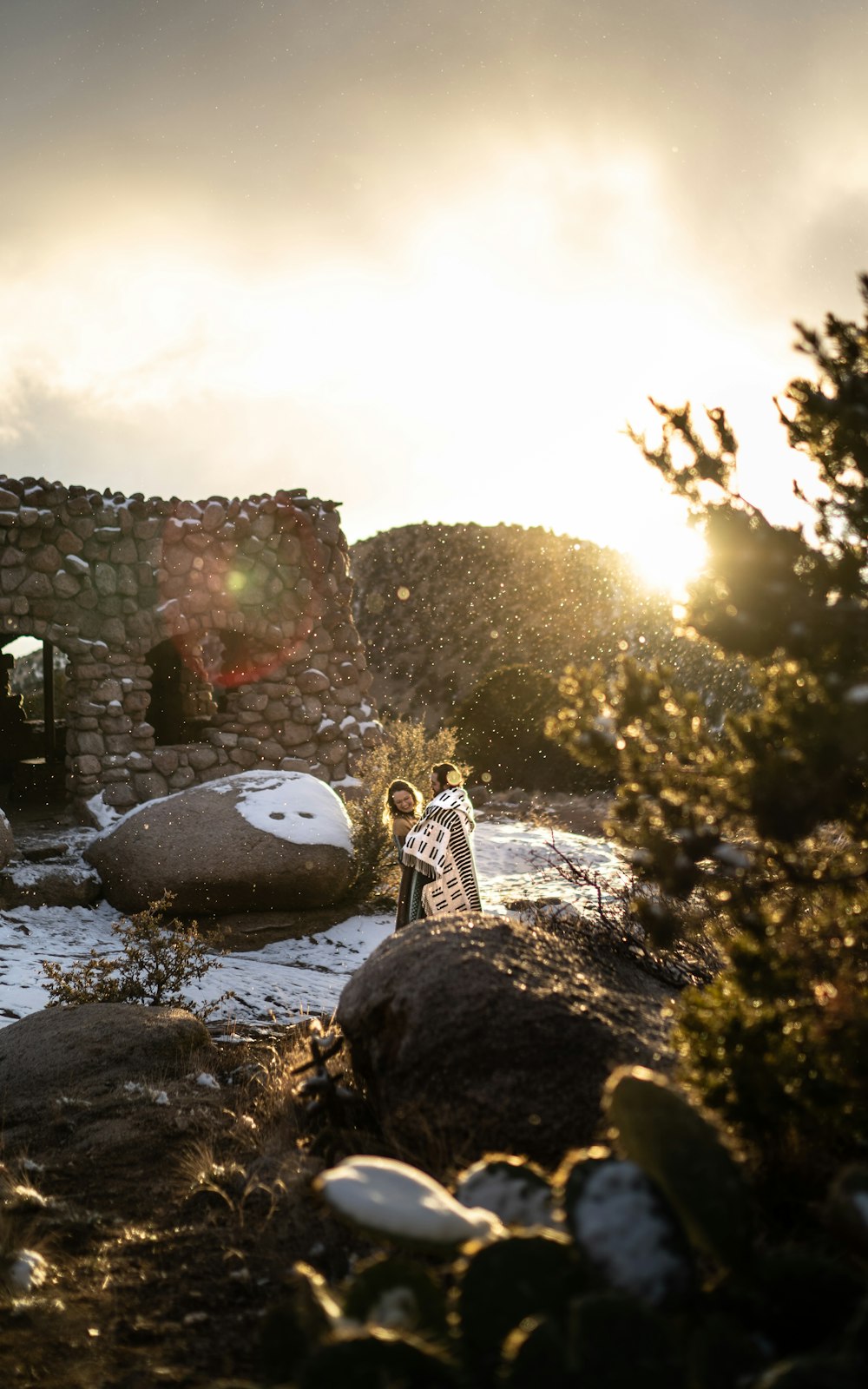 a woman standing on a rocky hillside next to a building